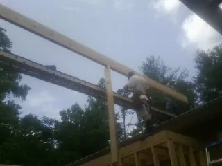 Carpenter setting a ridge beam over a new addition frame — Ice Dam Removal by Roofing Brothers in Millis