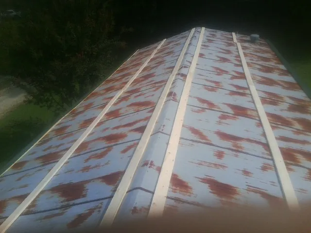 Rusted metal roof panels with new wood purlins before replacement — Storm Damage Roof Repair in Millis by Roofing Brothers