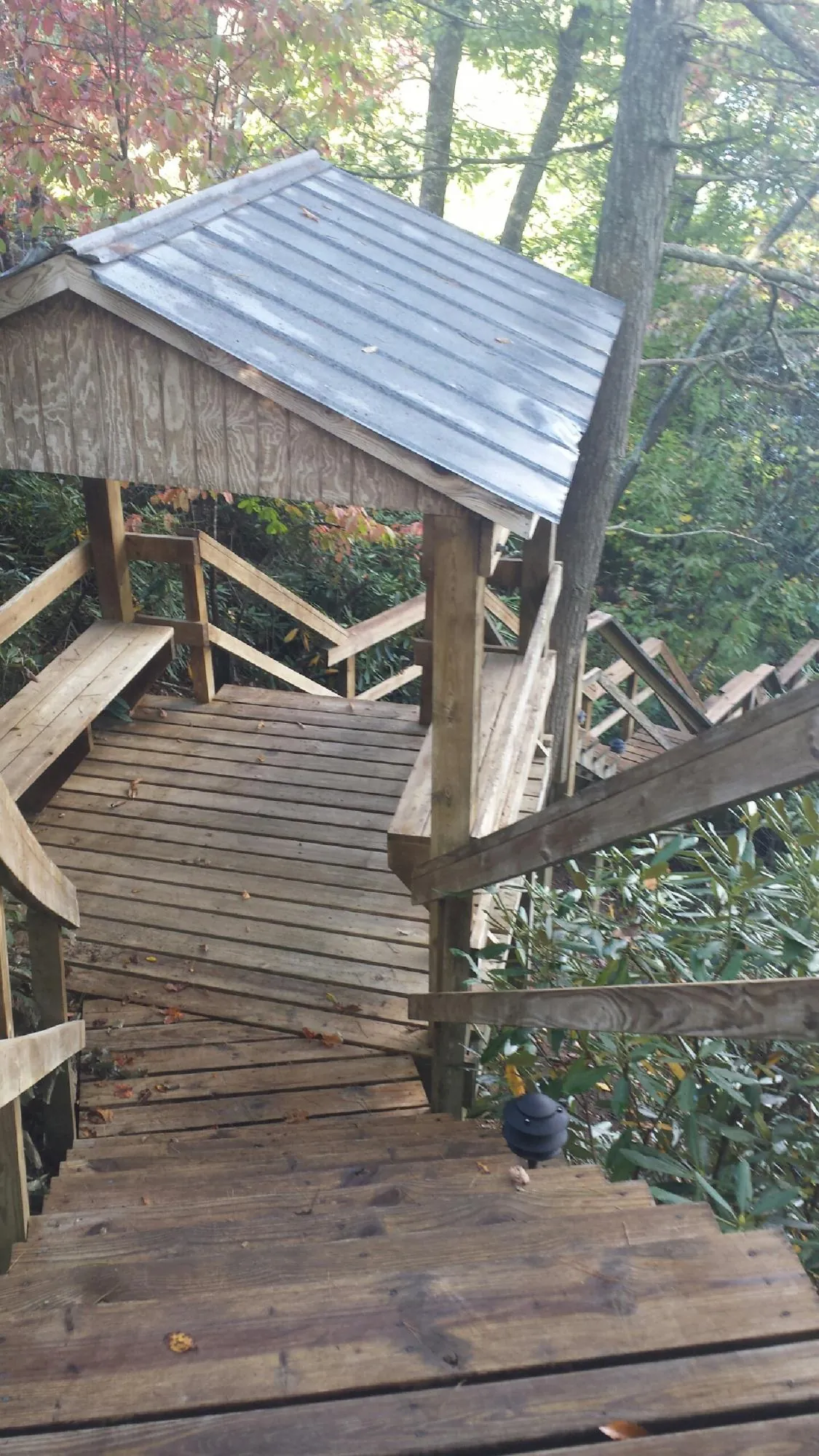 Metal roofed shelter over wooden steps on a wooded walkway — Skylight Repair & Installation work by our crew in Millis