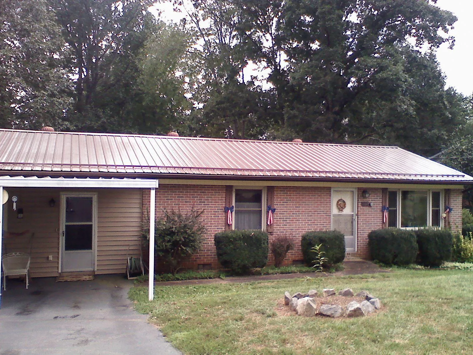 Bronze metal roof and carport on a brick ranch home — Roof Repair work by our crew in Millis